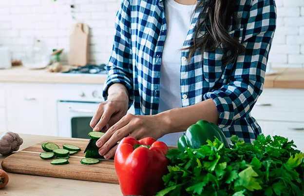 woman in kitchen chopping vegetables