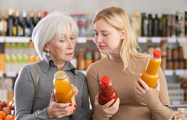 women looking at orange and red products at grocery store
